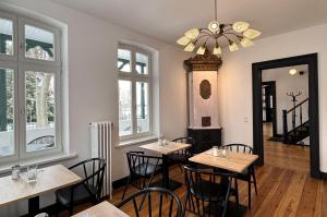a dining room with tables and chairs and windows at Backbord Geesthacht in Geesthacht