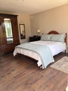 a bedroom with a large bed and a wooden floor at La Ramée - 2 bedroom - Wi-Fi - Garden - Parking in Saint-Siméon