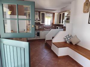 a kitchen with white cabinets and a bench in a room at Villa Ioanna in Agkidia +16 photos