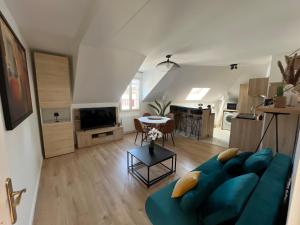 a living room with a blue couch and a table at L inattendu in Brie-Comte-Robert