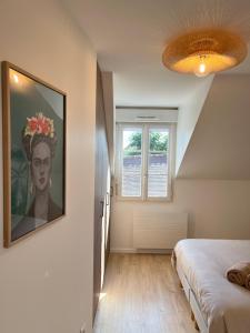 a bedroom with a painting on the wall and a bed at L inattendu in Brie-Comte-Robert