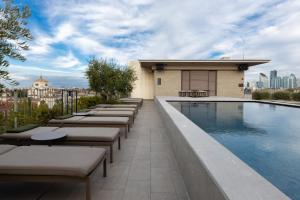 a row of lounge chairs next to a swimming pool at Hotel VIU Milan, a Member of Design Hotels in Milan
