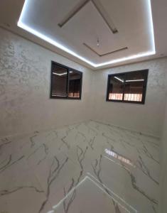 a room with a marble floor and two windows at Benslimane in Ben Slimane