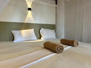 a bedroom with a bed with two pillows on it at Uluwatu Surf Hostel - Arugambay in Arugam Bay