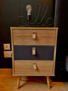 a wooden dresser with a light on top of it at R.Suite in Saint-Étienne