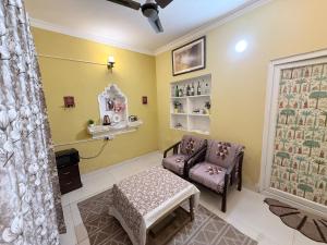 a waiting room with a chair and a stool at Staylo Suites Edit in New Delhi +130 photos