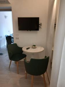 a living room with a table and chairs and a tv at B&B Casaletto in San Nicola Arcella