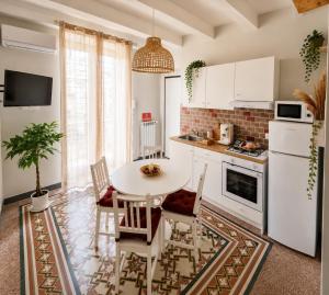 a kitchen with a white table and chairs in a room at Maison La Reggia in Caserta