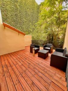 a deck with couches and chairs on a balcony at R.Suite in Saint-Étienne
