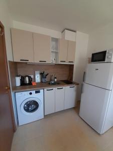 a kitchen with a white refrigerator and a washing machine at Apartment Sommer-Tango in Byala