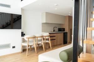 a kitchen and living room with a table and chairs at Rêve Studio Apartments in Sarandë