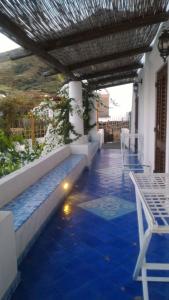 eine Terrasse mit blauem Fliesenboden sowie einem Tisch und Stühlen in der Unterkunft Casa Francesca in Stromboli