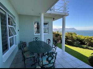 a patio with a table and chairs on a house at Whale and Waddle in Rocklands