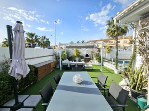 an outdoor patio with a table and umbrella at Chalet con Piscina Privada, Aguas Nuevas, Torrevieja in Torrevieja