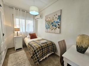 a bedroom with a bed and a table with a lamp at Chalet con Piscina Privada, Aguas Nuevas, Torrevieja in Torrevieja +19 photos