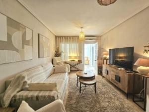 a living room with a couch and a tv at Chalet con Piscina Privada, Aguas Nuevas, Torrevieja in Torrevieja