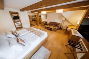 a bedroom with a large bed and a living room at U Černého medvěda in Jablonné nad Orlicí