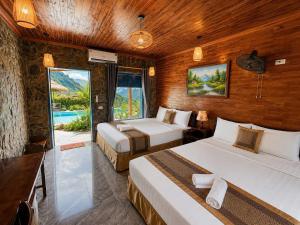 a hotel room with two beds and a balcony at Trang An River Sunshine in Ninh Binh +35 photos