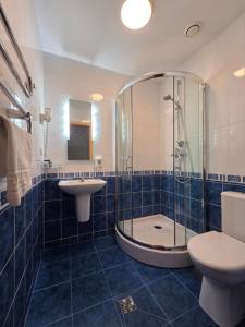 a bathroom with a shower and a toilet and a sink at Synet CoLiving in Mažeikiai +104 photos