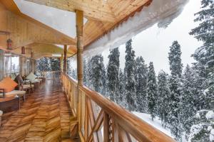 a balcony with a view of the snow covered trees at Hotel Royal Castle in Gulmarg