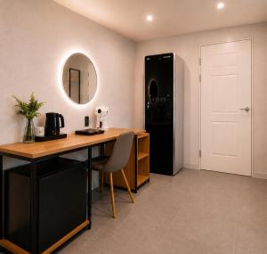 a kitchen with a desk and a black refrigerator at Busan Station Iruda Hotel in Busan