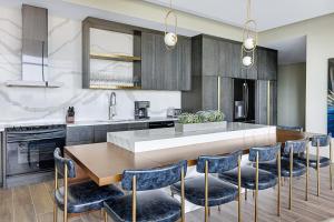a kitchen with a wooden table and blue chairs at Atlanta Resort 2BR Apartment in Atlanta