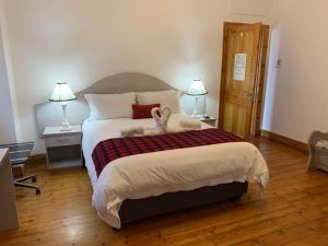 a bedroom with a bed with a stuffed animal on it at Savoy Hotel Beaufort-West in Beaufort West