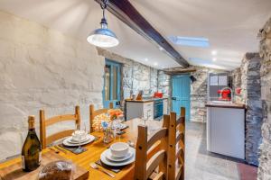 a kitchen and dining room with a wooden table and chairs at Y Cwtch - Panoramic mountain views within Snowdonia's National Park - 4x4 only in Dolgellau