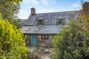 an old stone house with a blue door at Y Cwtch - Panoramic mountain views within Snowdonia's National Park - 4x4 only in Dolgellau