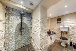 a bathroom with a toilet and a tile wall at Y Cwtch - Panoramic mountain views within Snowdonia's National Park - 4x4 only in Dolgellau +41 photos