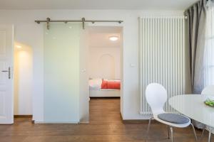 a room with a white table and chairs and a bed at Alte Schule Reichenau an der Rax in Reichenau