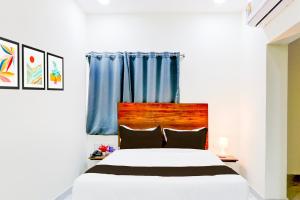 a bedroom with a white bed with blue curtains at Super Collection O SS BLUE INN in Hyderabad
