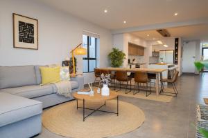 a living room with a couch and a table at Taluga Beach Villa in St. Helena Bay