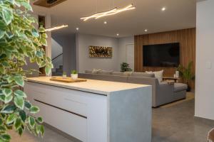 a kitchen and living room with a couch and a tv at Taluga Beach Villa in St. Helena Bay