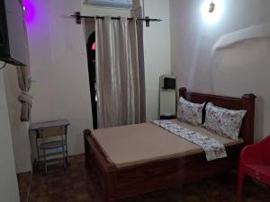 a bedroom with a bed and a chair in a room at MAKAPUS Stone Town Apartments in Zanzibar City