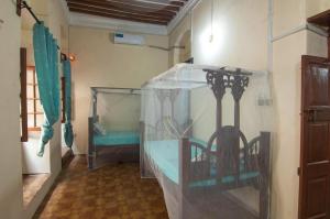 a room with a room with a bed with a clear tent at MAKAPUS Stone Town Apartments in Zanzibar City