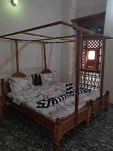 a bed in a bedroom with a wooden bed frame at MAKAPUS Stone Town Apartments in Zanzibar City
