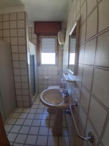 a small bathroom with a sink and a window at Casa vacanze ESTER in San Foca +14 photos