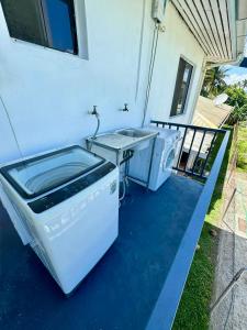 a washing machine and a table on a patio at BOU's Accomodation in Nadi
