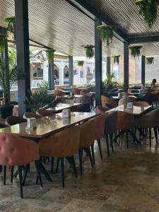 a restaurant with tables and chairs in a building at Vila DVG Tineret in Schitul