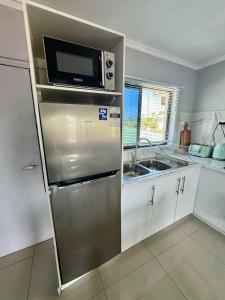a kitchen with a stainless steel refrigerator and a microwave at BOU's Accomodation in Nadi