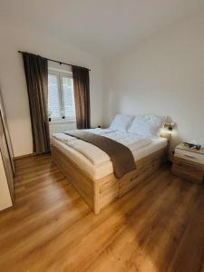 a bedroom with a large bed with a wooden floor at Serenity Apartment in Mariánské Lázně