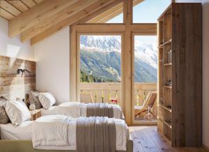 a bedroom with two beds and a large window at Ma Chérie in Livigno