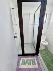 a bathroom with a bath sign on a purple rug at BOU's Accomodation in Nadi
