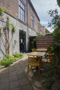 a patio with tables and chairs in front of a building at The Guesthouse in Gouda