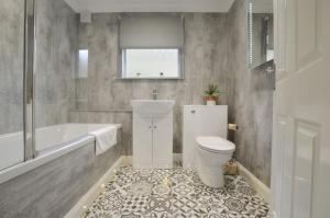 a bathroom with a toilet and a tub and a sink at Muck in Oban