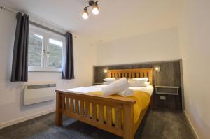 a bedroom with a bed with yellow sheets and pillows at Muck in Oban