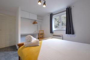 a bedroom with a bed with a towel on it at Muck in Oban