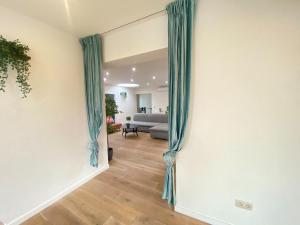 a view of a living room with blue curtains at 12-Guest Apartment on the Main Square in Antwerp