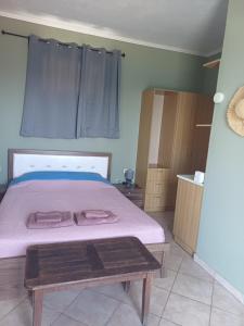 a bedroom with a bed with pink sheets and a table at Petani Beachside Accommodation in Vóvikes +32 photos